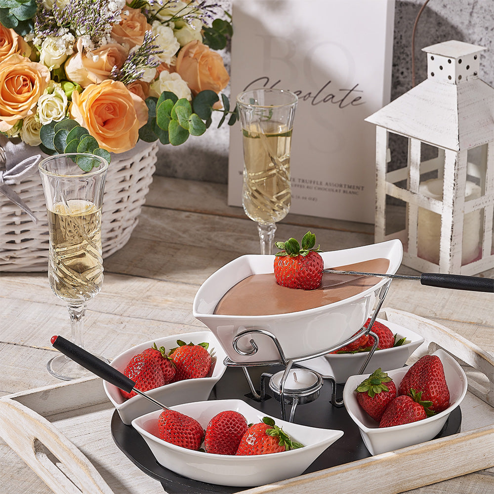 Fondue set with strawberries and champagne on a wooden table.