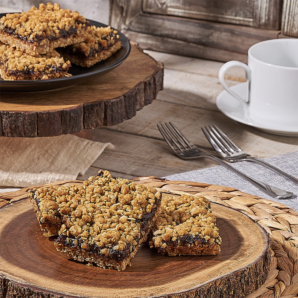 Oatmeal cookie bars on a wooden plate with a cup of coffee in the background.